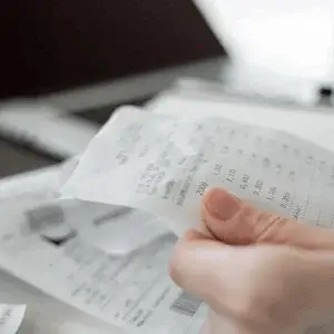 A printed bank payment slip held in one hand